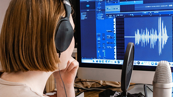 Depiction of video sound normalization using a woman recording audio Woman recording and editing her video's sound to illustrate normalization of video audio