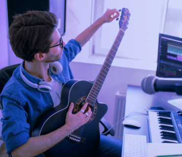 Creating your own song Man with headphones tunes guitar