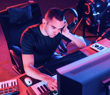 Editing WAV files Man, with headphones in front of keyboard and PC